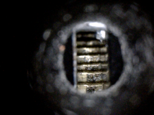 A close up of a keyhole in a dark room.